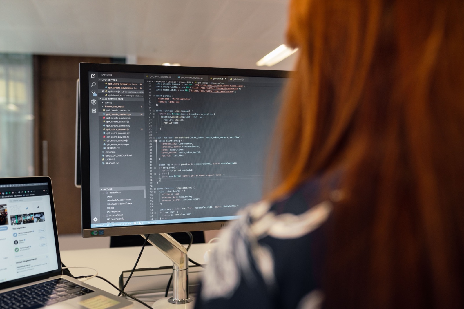 An engineer working through code on a large monitor, seen from behind